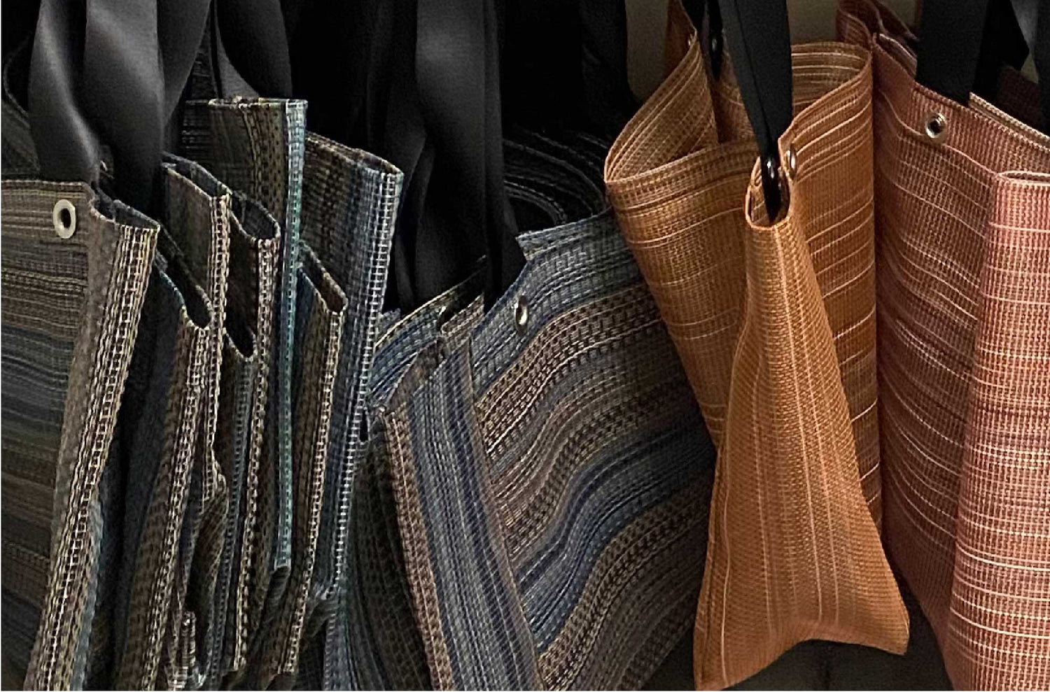 Series of hanging upcycled tote bags and recycled grocery bags.